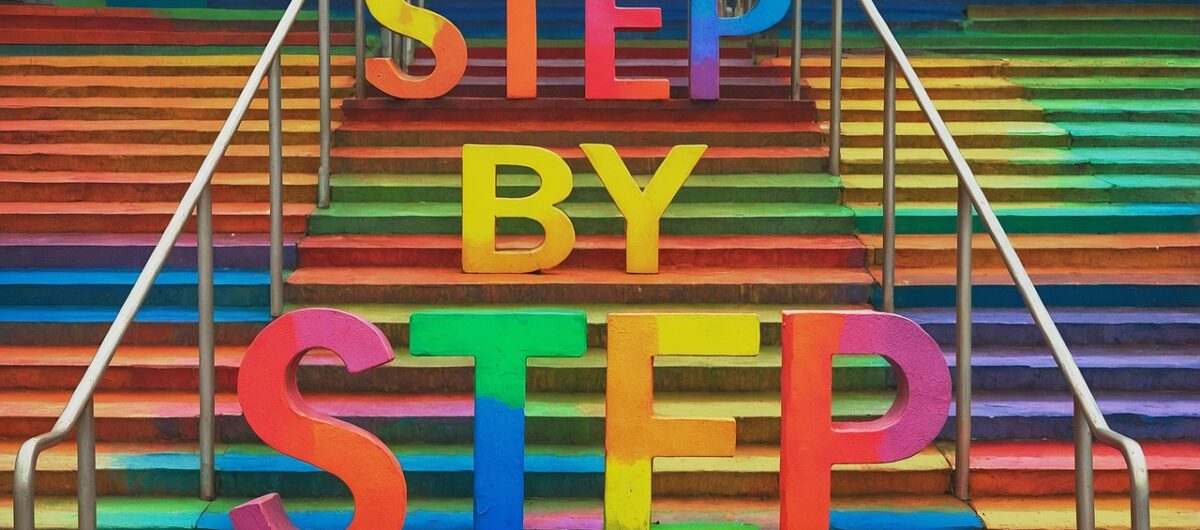 Vibrant rainbow stairs with bold 3D letters spelling “STEP BY STEP,” symbolizing progress, motivation, and personal growth.