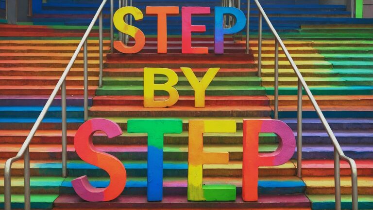 Vibrant rainbow stairs with bold 3D letters spelling “STEP BY STEP,” symbolizing progress, motivation, and personal growth.