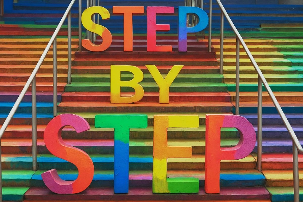 Vibrant rainbow stairs with bold 3D letters spelling “STEP BY STEP,” symbolizing progress, motivation, and personal growth.